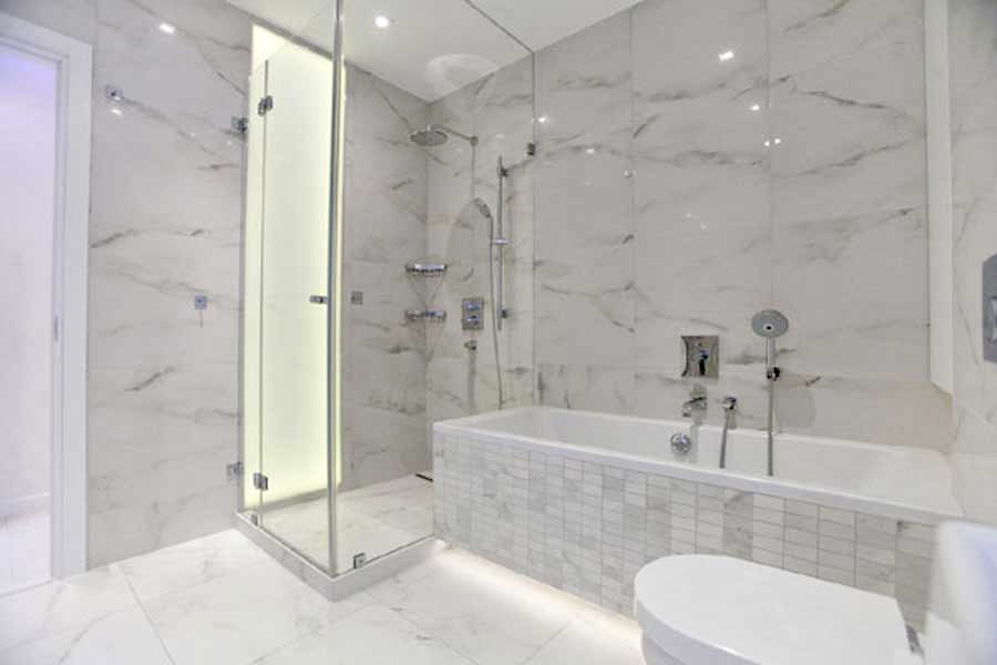 Marble-look walk-in shower and soaking tub with tile flooring